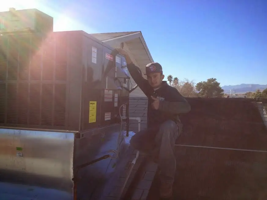 HVAC technician performing HVAC Inspection on a rooftop unit in Bourbonnais